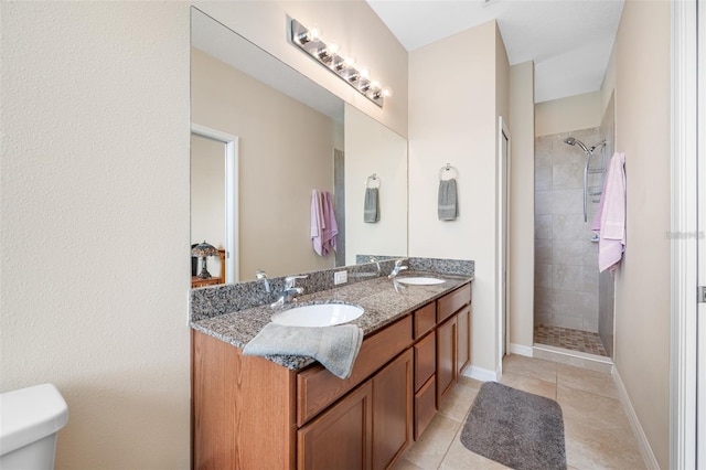 bathroom featuring tiled shower, vanity, and tile patterned flooring