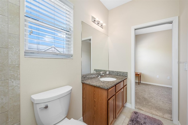 bathroom featuring toilet, tile patterned floors, baseboards, and vanity