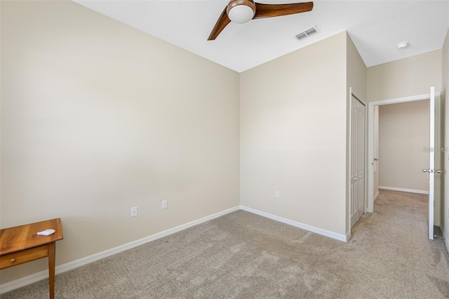 unfurnished room with visible vents, ceiling fan, light carpet, and baseboards