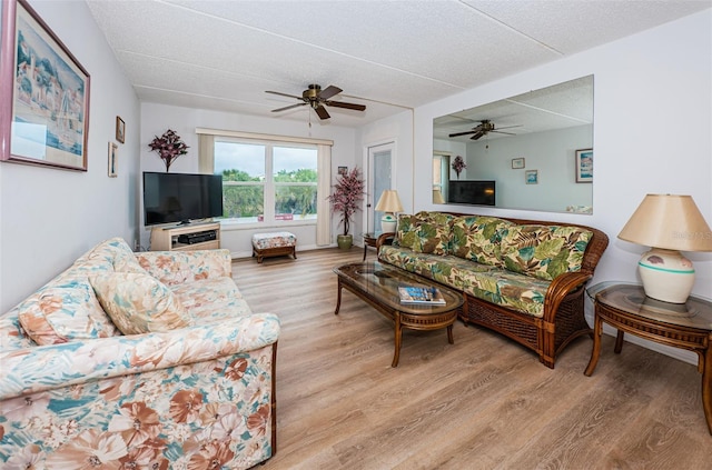 living room featuring light wood-type flooring and a textured ceiling