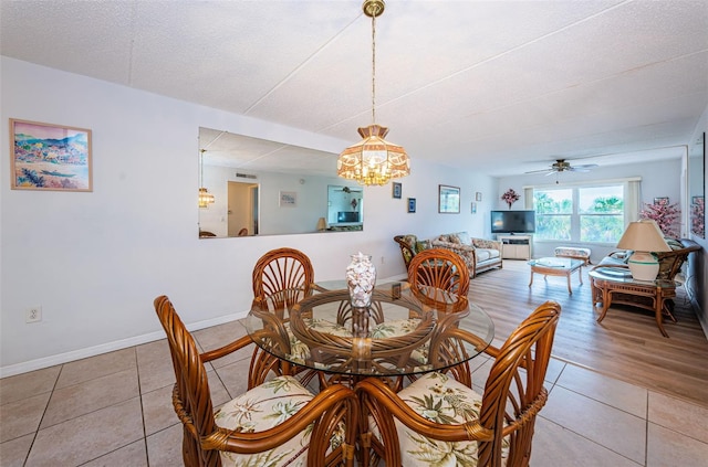 dining room featuring ceiling fan with notable chandelier and light tile patterned floors