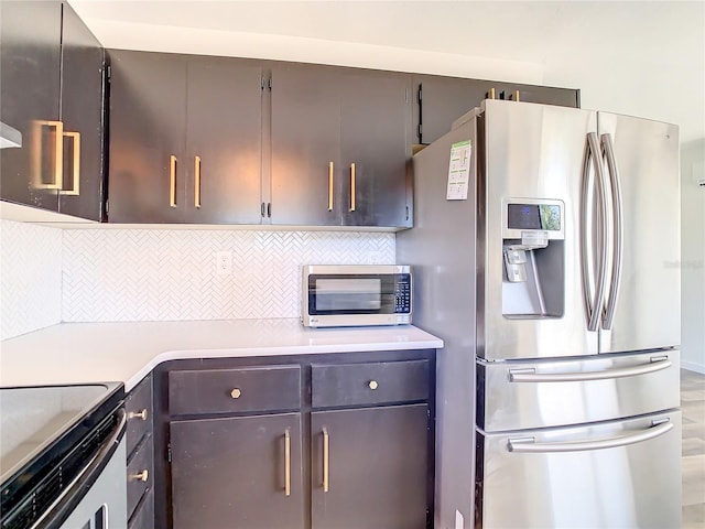 kitchen with appliances with stainless steel finishes and backsplash