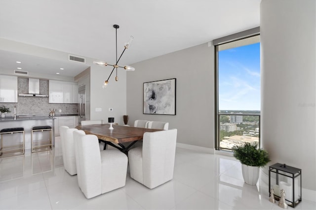 tiled dining space featuring expansive windows and a chandelier