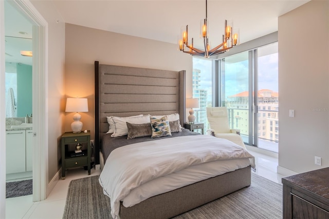 bedroom featuring an inviting chandelier, ensuite bath, and access to outside