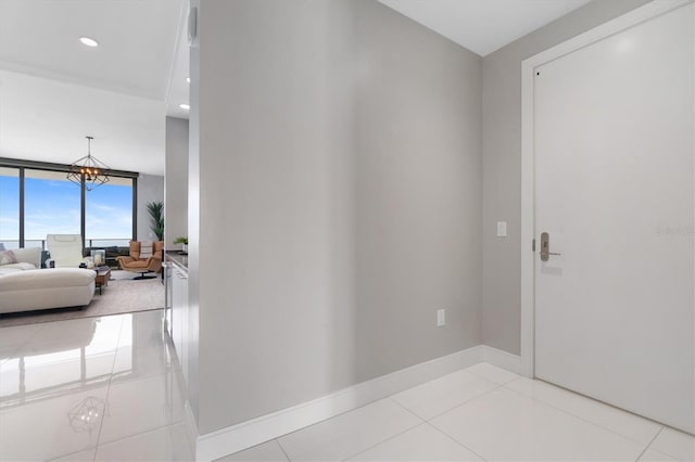 hallway featuring expansive windows, light tile patterned floors, and a notable chandelier