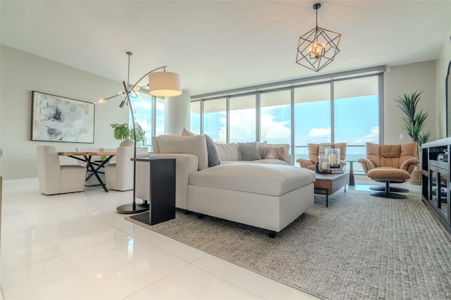 living room with tile patterned flooring, a chandelier, and a wall of windows