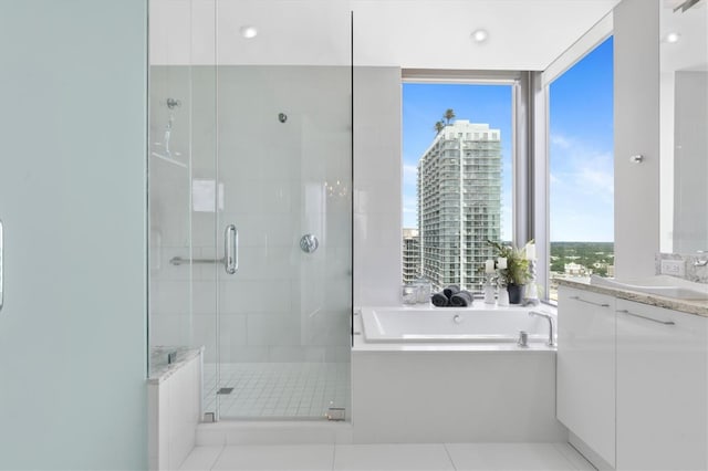 bathroom featuring a garden tub, vanity, a city view, and a stall shower