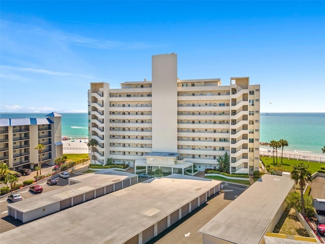 view of building exterior with a water view and a beach view