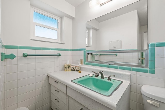 bathroom with vanity, tile walls, and toilet