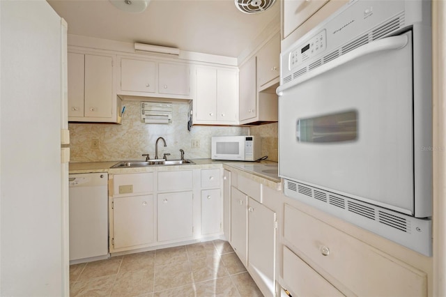 kitchen featuring white cabinets, light tile patterned floors, white appliances, and sink