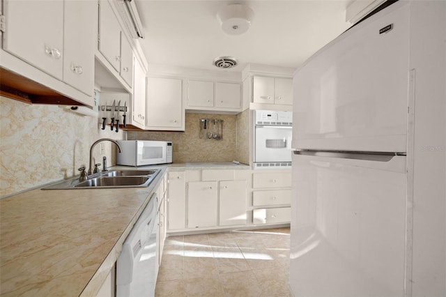 kitchen with light tile patterned floors, white appliances, white cabinetry, and sink