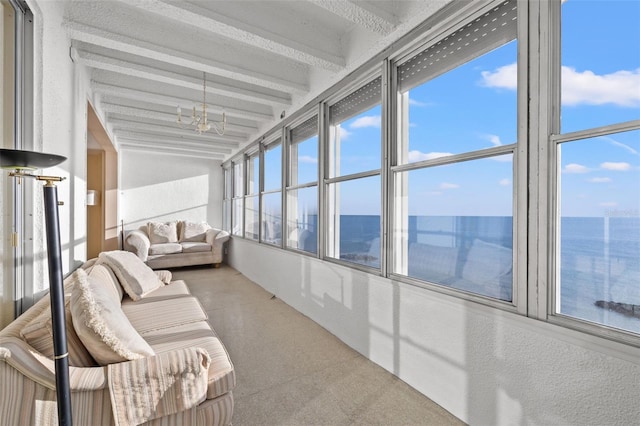 sunroom / solarium featuring lofted ceiling with beams, a water view, and a notable chandelier