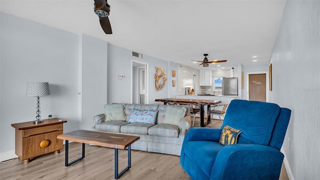 living room featuring ceiling fan and light hardwood / wood-style flooring