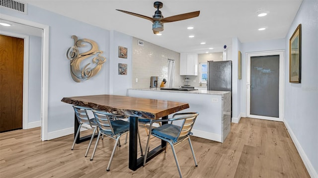 dining room with ceiling fan and light hardwood / wood-style flooring