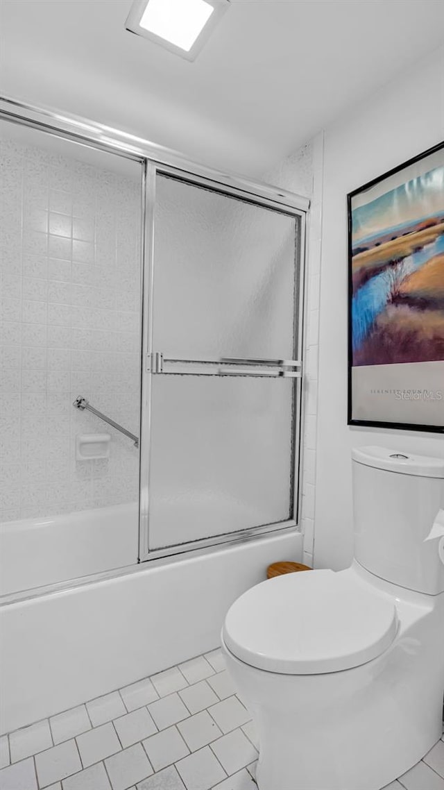 bathroom featuring toilet, tile patterned flooring, and enclosed tub / shower combo