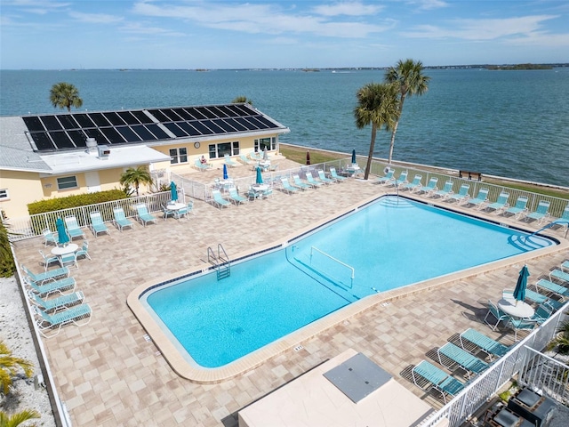 view of pool featuring a patio area and a water view