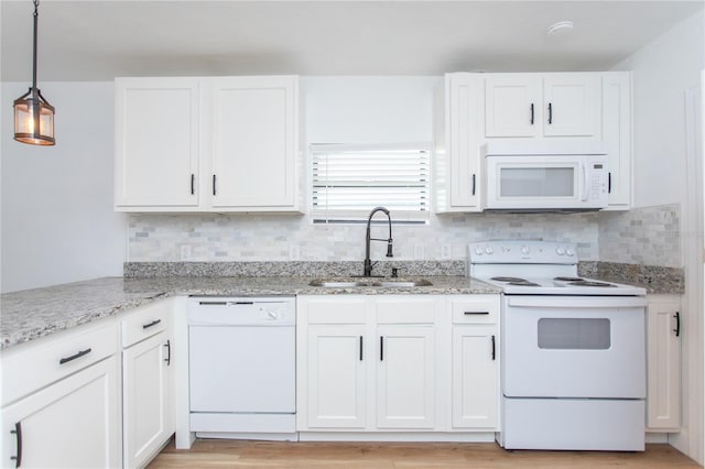 kitchen featuring light wood-type flooring, white appliances, sink, pendant lighting, and white cabinets