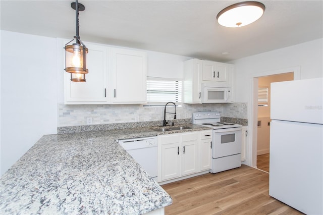 kitchen with white cabinetry, sink, pendant lighting, white appliances, and light wood-type flooring