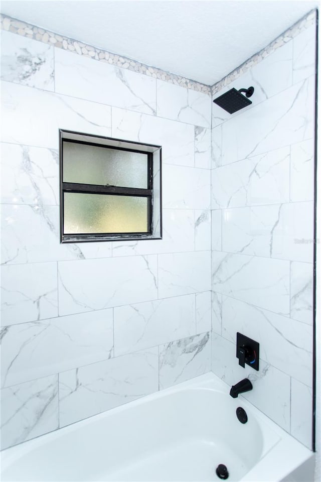 bathroom with tiled shower / bath combo