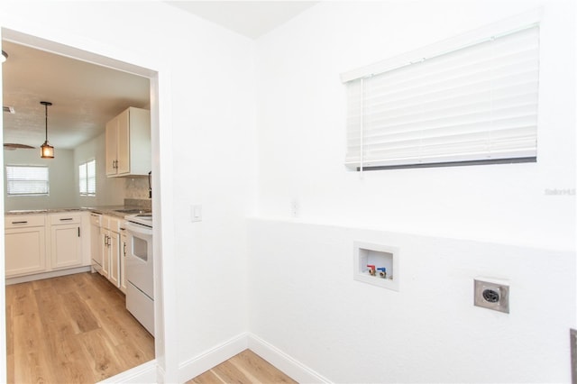 washroom with hookup for an electric dryer, light hardwood / wood-style floors, and washer hookup