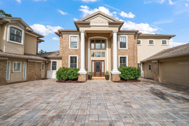 greek revival inspired property featuring a garage