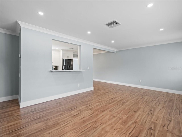 unfurnished living room with crown molding and light wood-type flooring