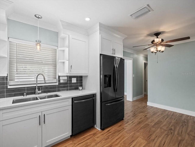 kitchen featuring sink, hanging light fixtures, tasteful backsplash, black appliances, and white cabinets