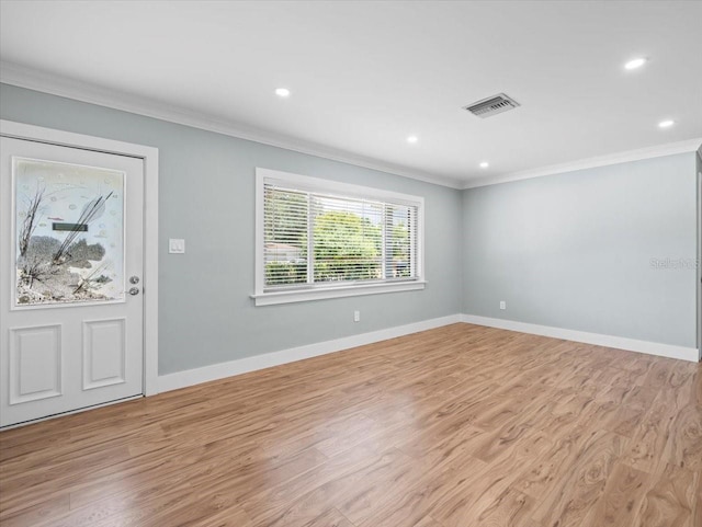 empty room with light hardwood / wood-style flooring and ornamental molding