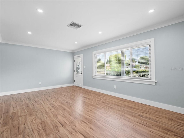 empty room with ornamental molding and light hardwood / wood-style flooring