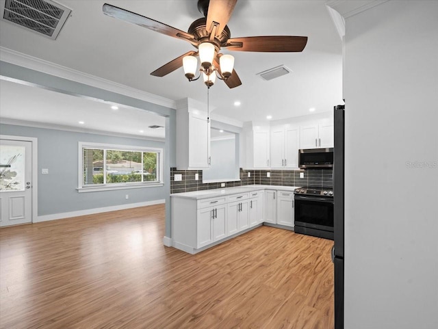 kitchen with stainless steel appliances, ornamental molding, white cabinets, decorative backsplash, and light wood-type flooring