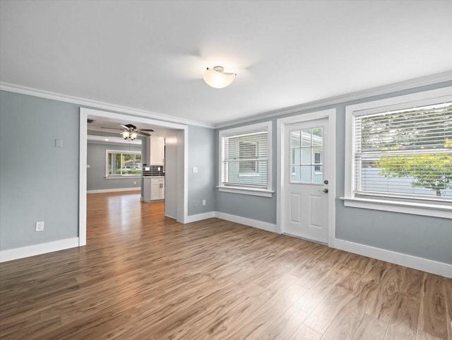 interior space with hardwood / wood-style flooring, ceiling fan, and crown molding