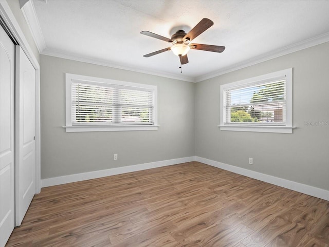 unfurnished bedroom featuring crown molding, wood-type flooring, a closet, and ceiling fan