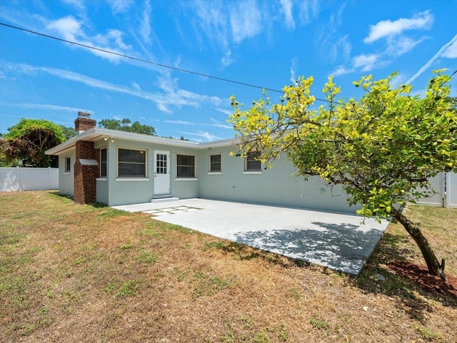 rear view of property with a lawn and a patio area