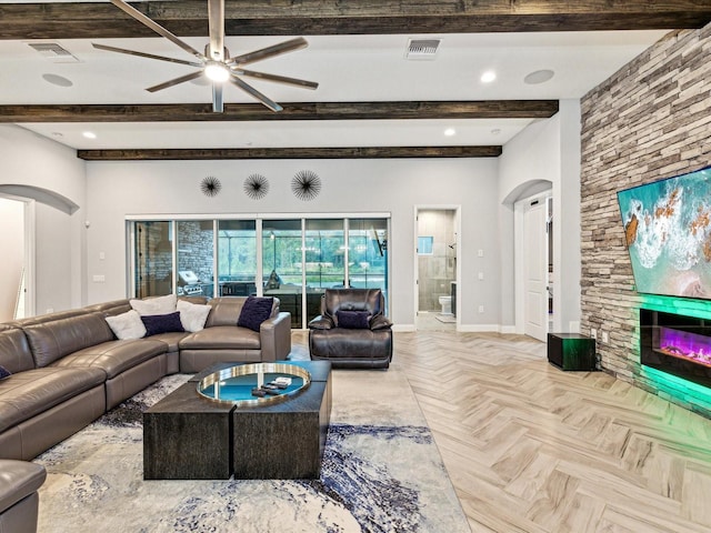 living room featuring a fireplace, beam ceiling, light parquet floors, and ceiling fan