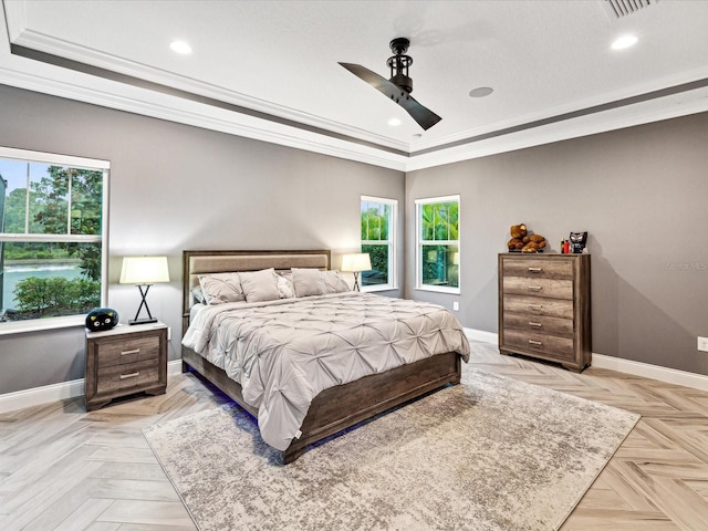 bedroom featuring light parquet flooring, a tray ceiling, ceiling fan, and ornamental molding