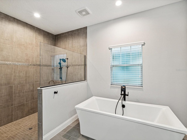 bathroom featuring tile patterned flooring, a textured ceiling, and independent shower and bath