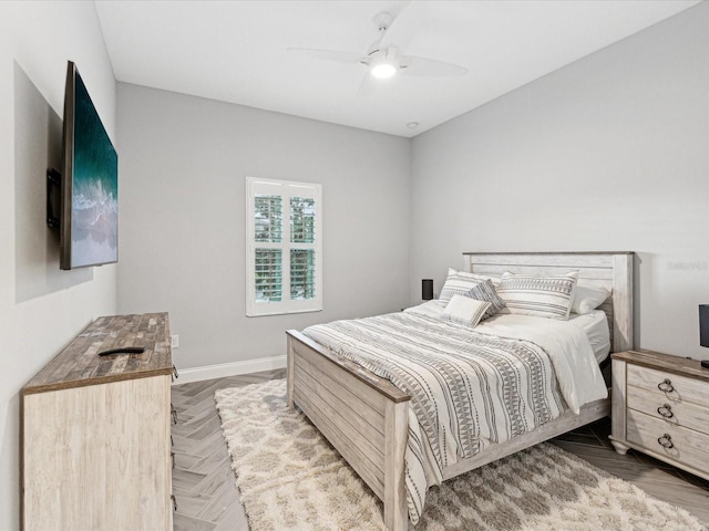 bedroom with ceiling fan and parquet flooring