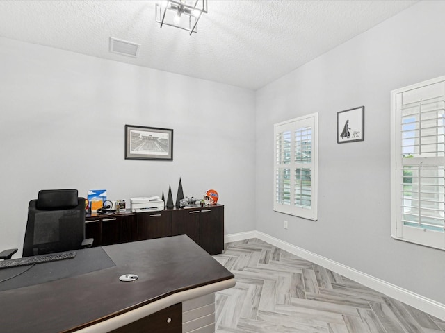 home office featuring a textured ceiling and light parquet flooring