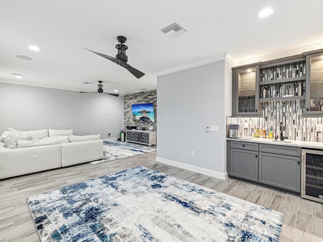 living room with wine cooler, ceiling fan, light hardwood / wood-style flooring, and wet bar