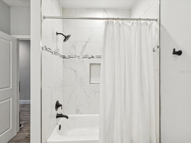 bathroom with shower / bathtub combination with curtain and wood-type flooring