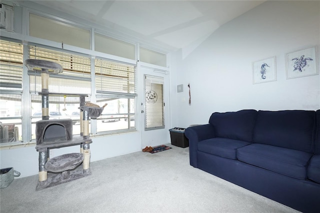 carpeted living area with vaulted ceiling