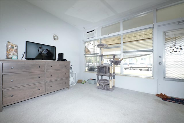 interior space with vaulted ceiling, an AC wall unit, and carpet flooring