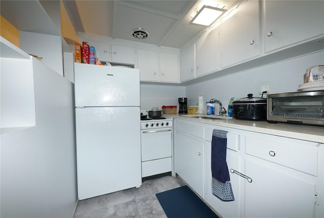 kitchen with sink, white appliances, and white cabinets