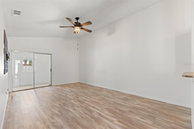 unfurnished room featuring a textured ceiling, ceiling fan, light hardwood / wood-style flooring, and vaulted ceiling