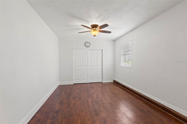 empty room with dark hardwood / wood-style flooring and ceiling fan