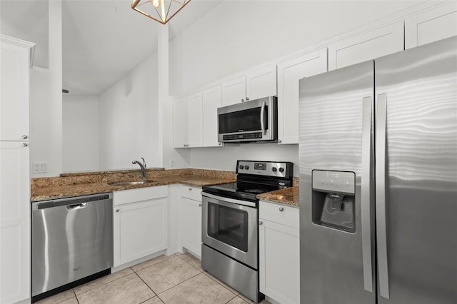 kitchen with sink, white cabinetry, stainless steel appliances, and dark stone counters