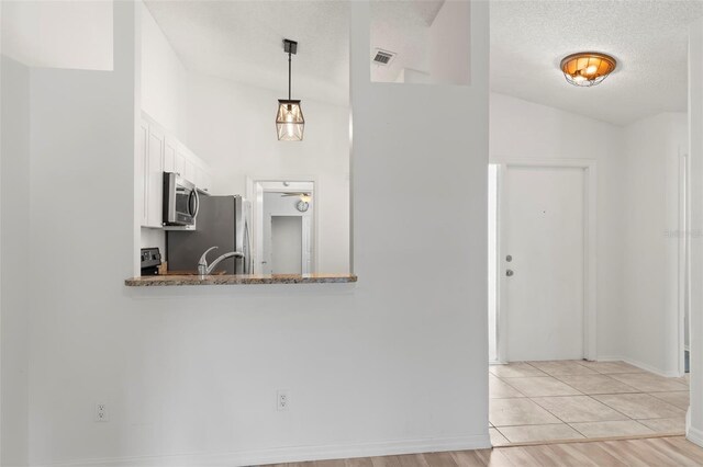 interior space featuring lofted ceiling, sink, ceiling fan, a textured ceiling, and light hardwood / wood-style floors