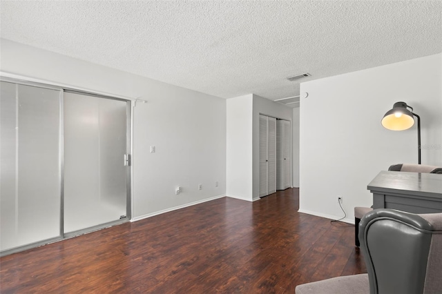 office with dark hardwood / wood-style floors and a textured ceiling