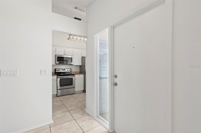 kitchen featuring white cabinetry, light tile patterned floors, and appliances with stainless steel finishes