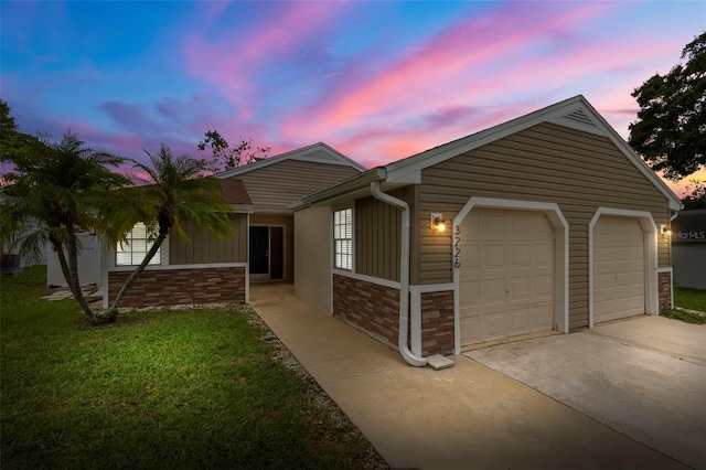 single story home featuring a garage and a yard